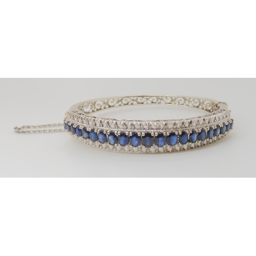 714 - AN 18K WHITE GOLD SAPPHIRE AND DIAMOND BANGLE