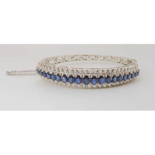 714 - AN 18K WHITE GOLD SAPPHIRE AND DIAMOND BANGLE