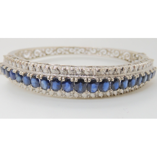 714 - AN 18K WHITE GOLD SAPPHIRE AND DIAMOND BANGLE