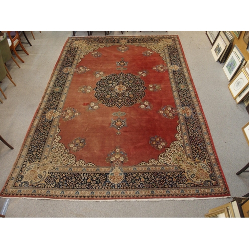 90 - A RED GROUND KESHAN RUG WITH BLUE CENTRAL MEDALLION AND MATCHING BORDER