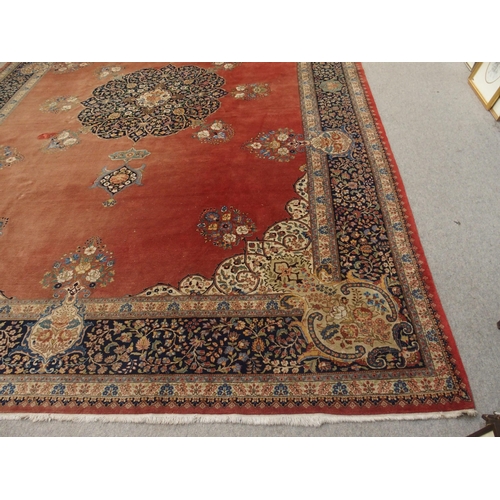 90 - A RED GROUND KESHAN RUG WITH BLUE CENTRAL MEDALLION AND MATCHING BORDER