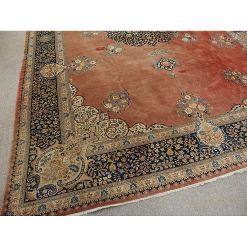 90 - A RED GROUND KESHAN RUG WITH BLUE CENTRAL MEDALLION AND MATCHING BORDER