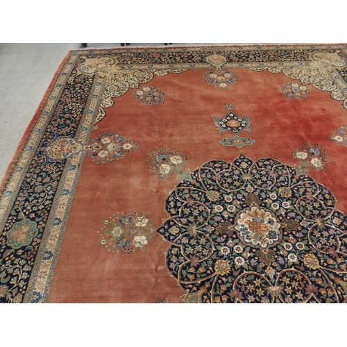 90 - A RED GROUND KESHAN RUG WITH BLUE CENTRAL MEDALLION AND MATCHING BORDER