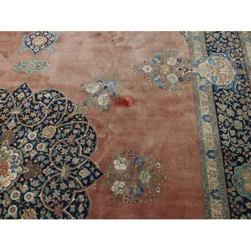 90 - A RED GROUND KESHAN RUG WITH BLUE CENTRAL MEDALLION AND MATCHING BORDER