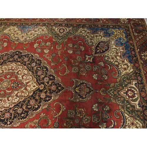 91 - A RED GROUND VINTAGE PERSIAN TABRIZ RUG WITH BLUE CENTRAL MEDALLION