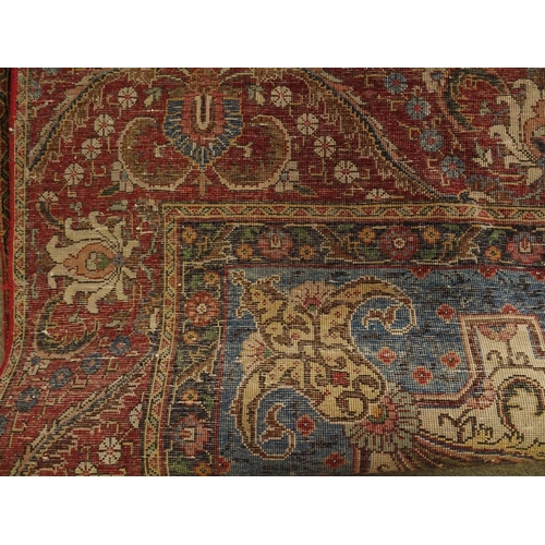 91 - A RED GROUND VINTAGE PERSIAN TABRIZ RUG WITH BLUE CENTRAL MEDALLION