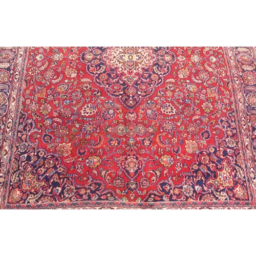 92 - A RED GROUND MESHED RUG