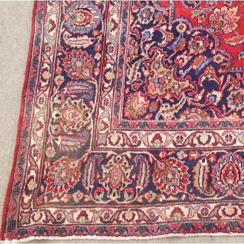 92 - A RED GROUND MESHED RUG