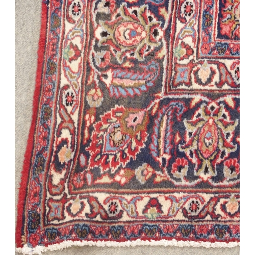 92 - A RED GROUND MESHED RUG