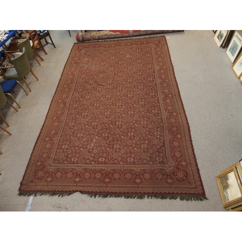 94 - A LARGE RED GROUND RUG WITH GEOMETRIC DESIGN