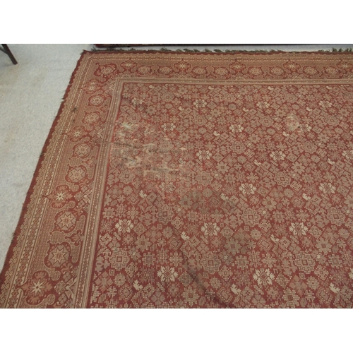 94 - A LARGE RED GROUND RUG WITH GEOMETRIC DESIGN