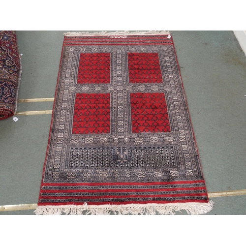 95 - AN EASTERN RUG WITH FOUR MAIN RED PANELS