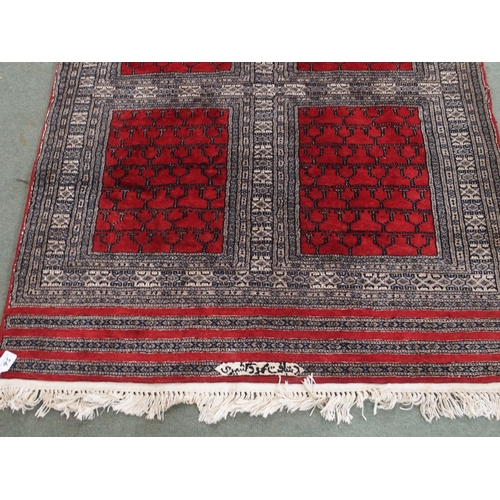 95 - AN EASTERN RUG WITH FOUR MAIN RED PANELS