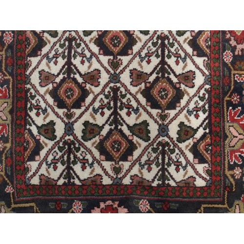 97 - A CREAM GROUND RUNNER WITH STYLISED FLOWERS