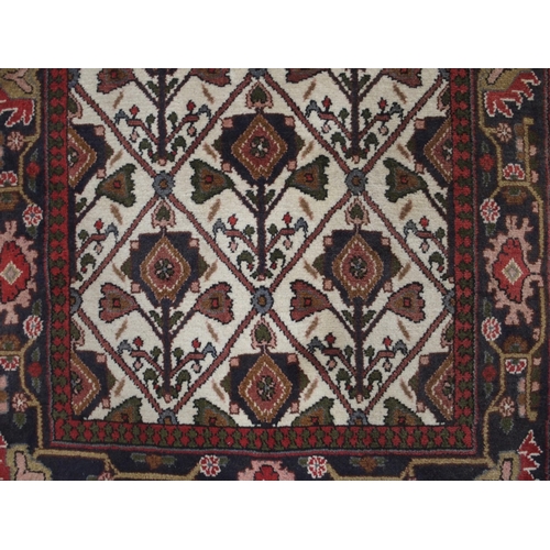 97 - A CREAM GROUND RUNNER WITH STYLISED FLOWERS