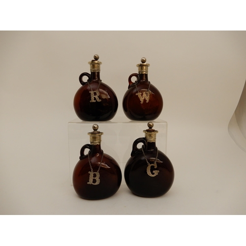 417 - A SET OF FOUR BROWN GLASS LIQUOR DECANTERS