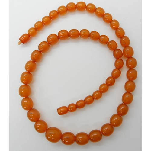 549 - A STRING OF AMBER COLOURED BEADS