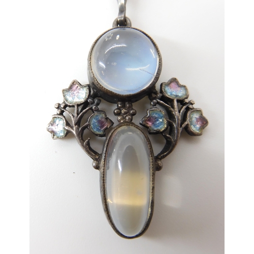 571 - A MOONSTONE AND ENAMEL PENDANT IN THE STYLE OF JESSIE M. KING