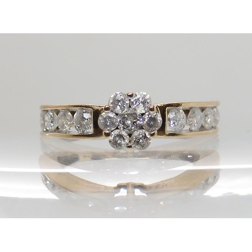 604 - A 9CT GOLD DIAMOND FLOWER RING