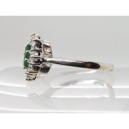 619 - A 9CT WHITE GOLD EMERALD AND DIAMOND CLUSTER RING