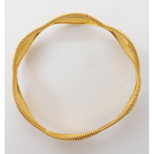 643 - A BRIGHT YELLOW METAL DECORATIVE BANGLE