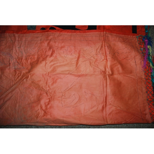 127 - A CHINESE SILK BANNER IN RED AND BLACK WITH CALLIGRAPHY