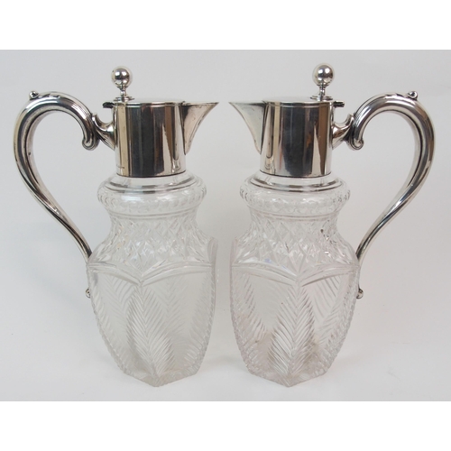 151 - A PAIR OF GERMAN SILVER MOUNTED CUT GLASS CLARET JUGS