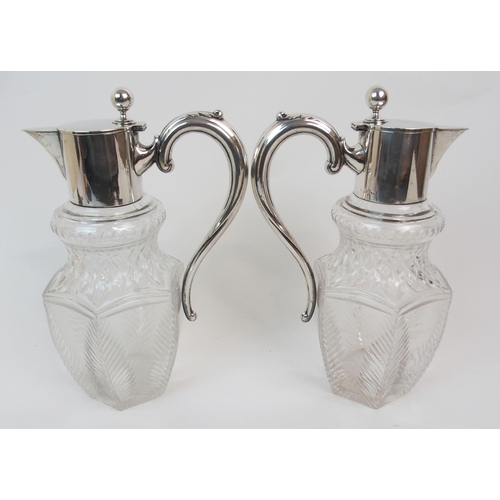 151 - A PAIR OF GERMAN SILVER MOUNTED CUT GLASS CLARET JUGS