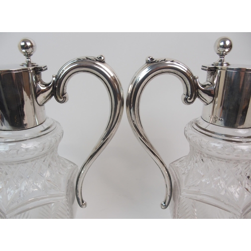 151 - A PAIR OF GERMAN SILVER MOUNTED CUT GLASS CLARET JUGS