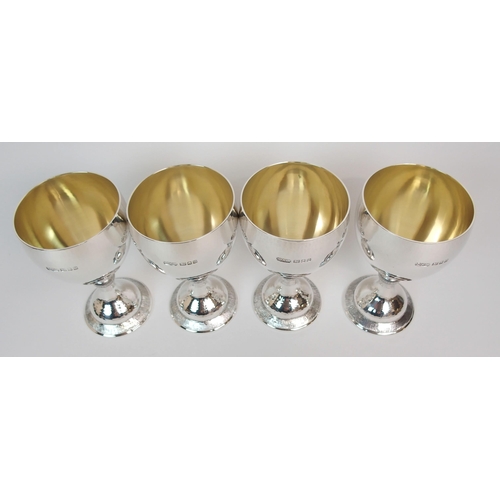 199 - A SET OF FOUR HAMMERED SILVER GOBLETS