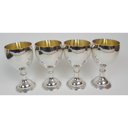 199 - A SET OF FOUR HAMMERED SILVER GOBLETS