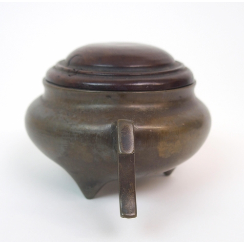 86 - A CHINESE BRONZE TWO-HANDLED CENSER AND HARDWOOD COVER