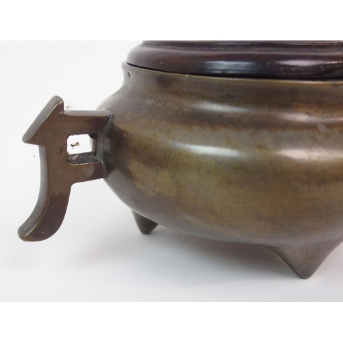 86 - A CHINESE BRONZE TWO-HANDLED CENSER AND HARDWOOD COVER