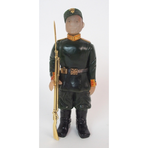 325 - A late 20th Century copy of a Faberge hard stone figure of a Cossack with yellow-metal rifle