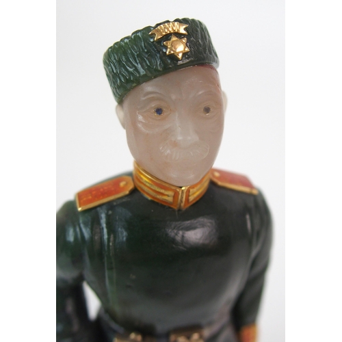 325 - A late 20th Century copy of a Faberge hard stone figure of a Cossack with yellow-metal rifle