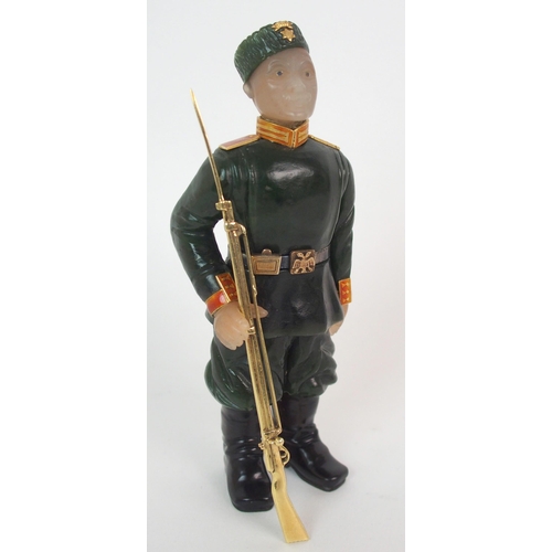 325 - A late 20th Century copy of a Faberge hard stone figure of a Cossack with yellow-metal rifle