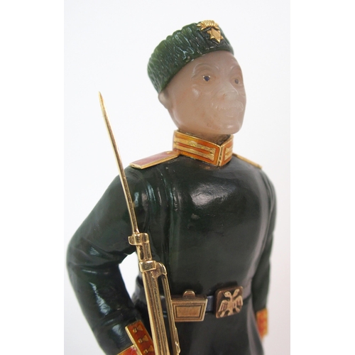 325 - A late 20th Century copy of a Faberge hard stone figure of a Cossack with yellow-metal rifle