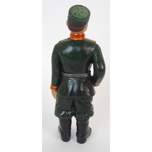 325 - A late 20th Century copy of a Faberge hard stone figure of a Cossack with yellow-metal rifle