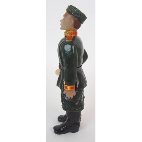 325 - A late 20th Century copy of a Faberge hard stone figure of a Cossack with yellow-metal rifle