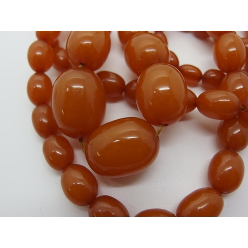 627 - A long string of amber coloured beads