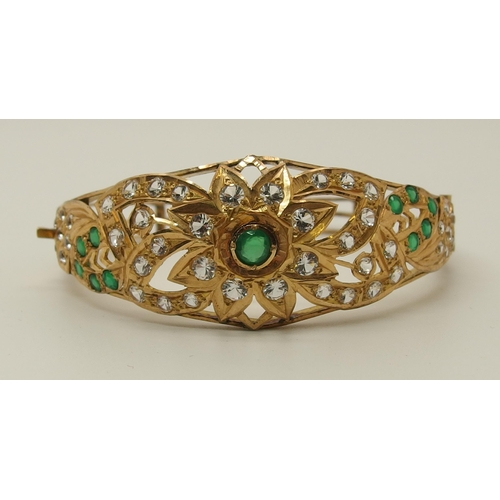 629 - A bright yellow bangle set with green and clear gems