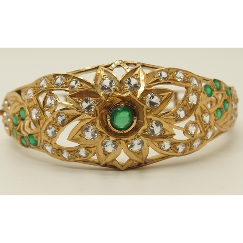 629 - A bright yellow bangle set with green and clear gems