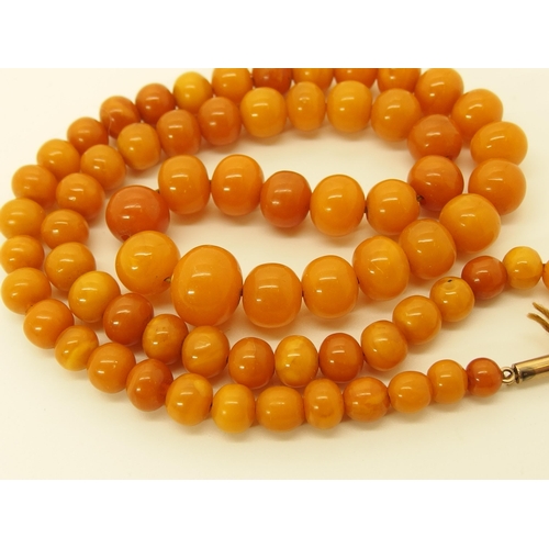 645 - A string of amber coloured beads