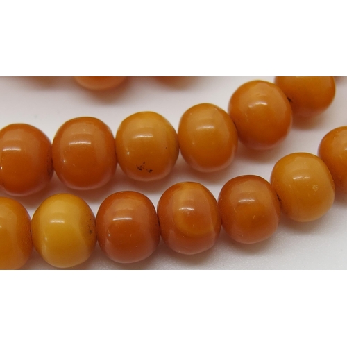 645 - A string of amber coloured beads