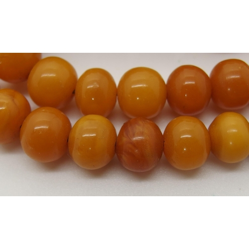 645 - A string of amber coloured beads