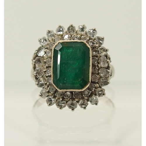 663 - An emerald and diamond cluster ring