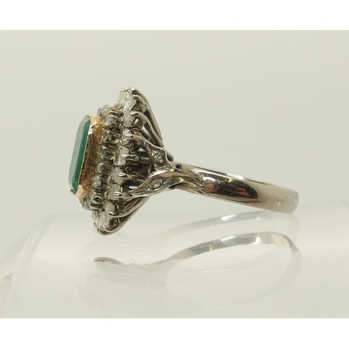 663 - An emerald and diamond cluster ring