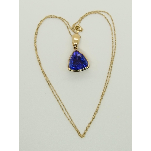 701 - An 18ct gold trilliant cut tanzanite and diamond pendant