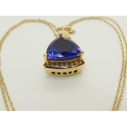 701 - An 18ct gold trilliant cut tanzanite and diamond pendant