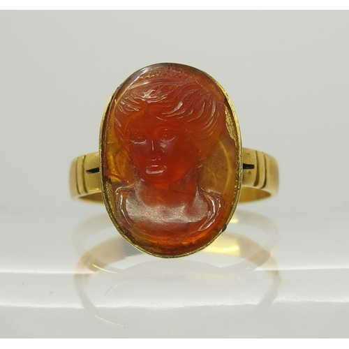 718 - A bright yellow metal ring set with a carved carnelian intaglio